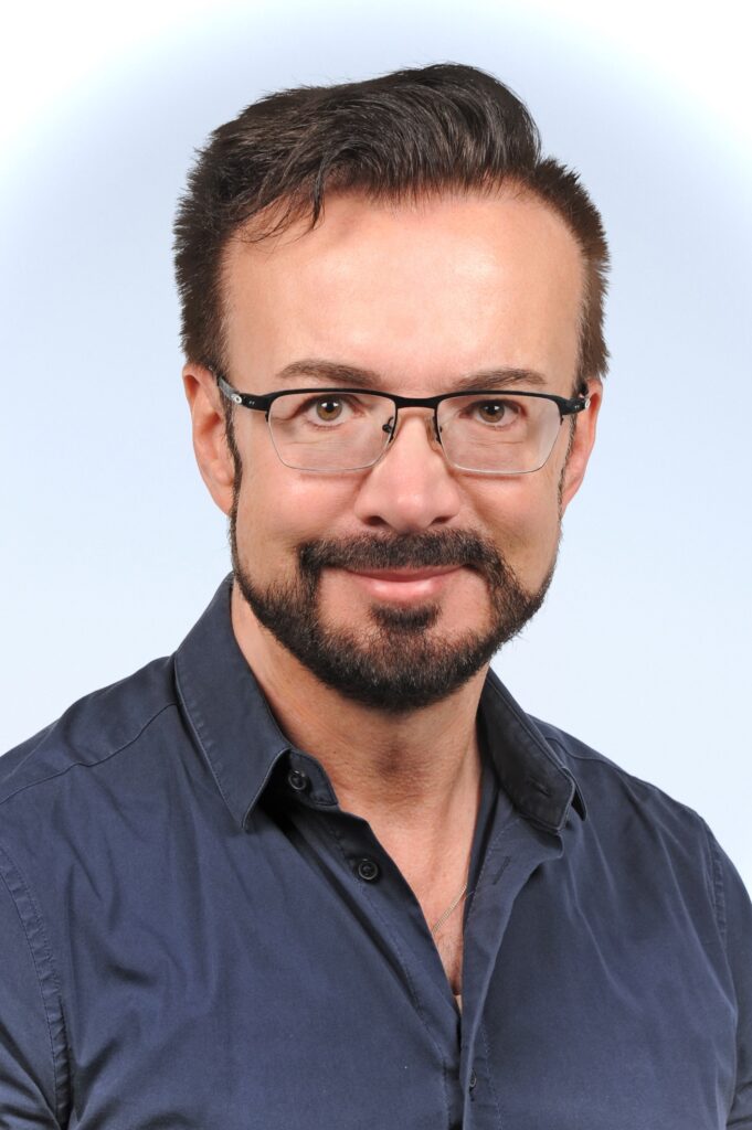 Frontal aufgenommenes Porträt von Univ.-Prof. Dr. med. dent. Dr. med. Dr. phil. Dominik Groß vor hellem Hintergrund.